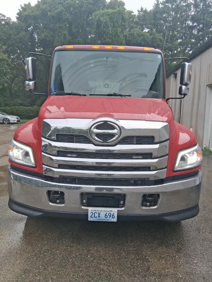 Red Hino flatbed and the black wrecker parked together