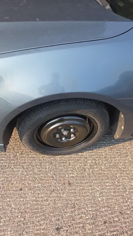 A spare wheel fitted at the roadside