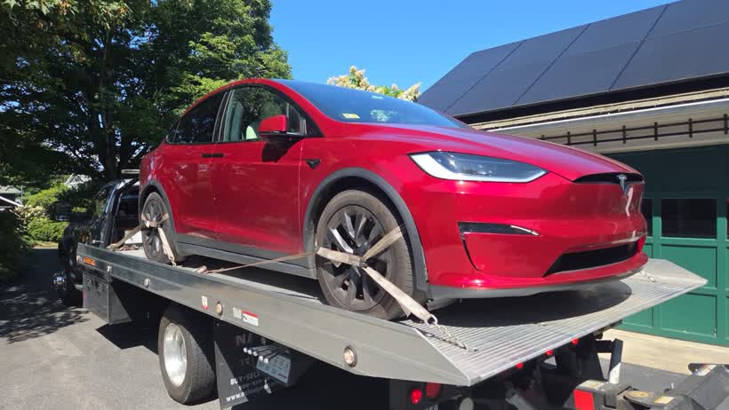 Red Tesla strapped down on the flatbed