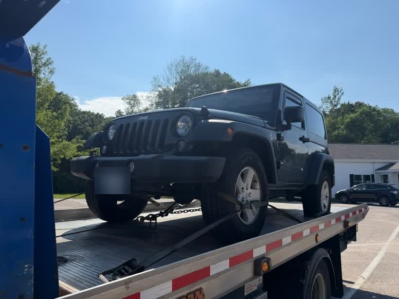 A Jeep strapped down on a Centri Auto flatbed